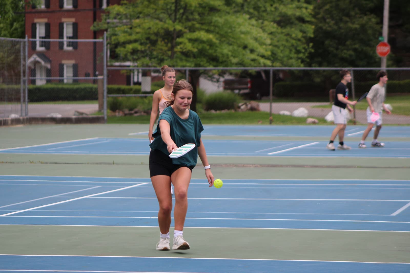 Older adults playing pickleball on a bright outdoor court